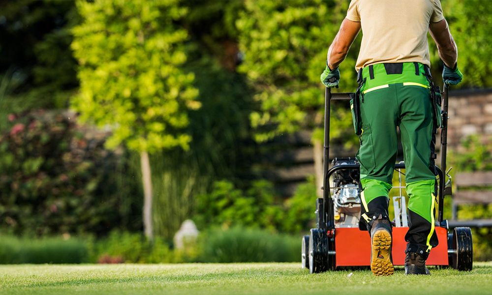 Professional HOA landscaping crew mowing grass and trimming trees for community curb appeal