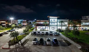 Well-lit modern retail center and office park at night in Northwest Houston with bright LED parking lot lighting and beautiful curb appeal