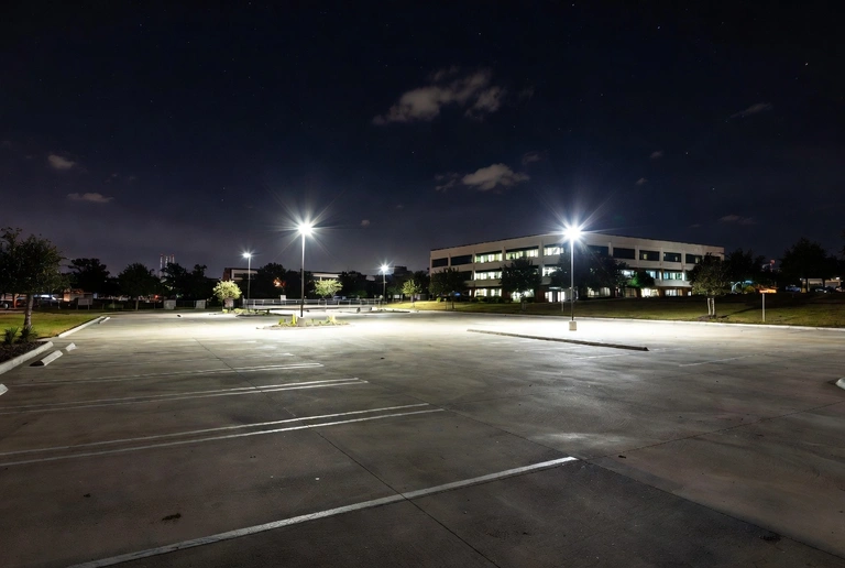 Brightly lit commercial parking lot at night demonstrating the safety benefits of professional landscape lighting